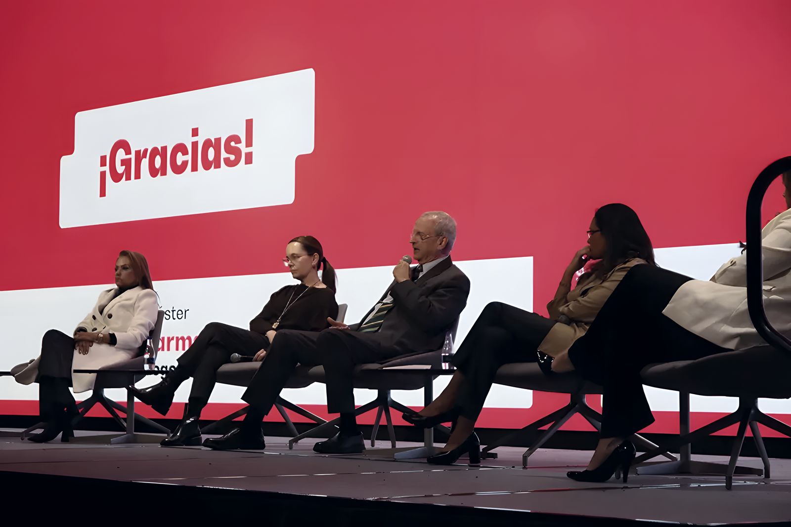 Panel de invitados sentados en el escenario del foro